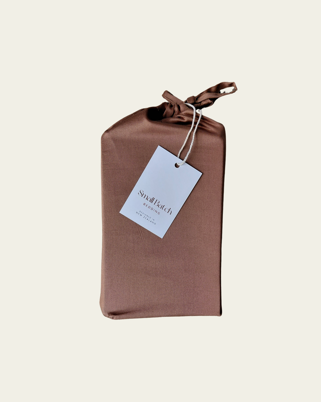 Brown cotton fabric pillowcase packaging with a Small Batch Bedding tag on a beige background
