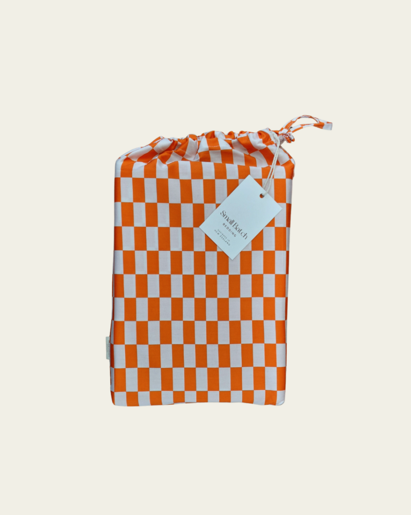 Checkered rectangle red orange protective cotton drawstring bag for fitted sheet with Small Batch Bedding tag on a light background
