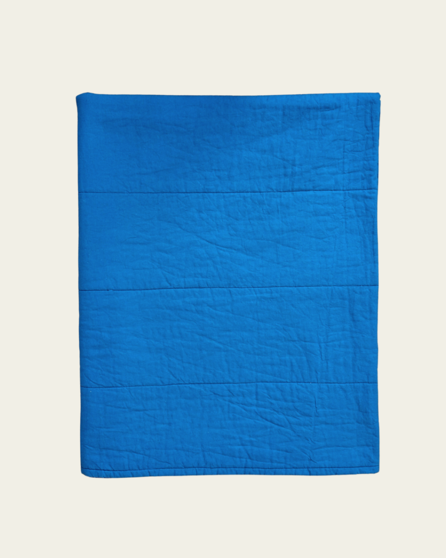 Blue cotton quilt on a beige background